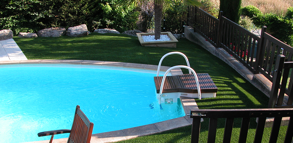 Gazon synthétique dans un jardin autour d'une piscine