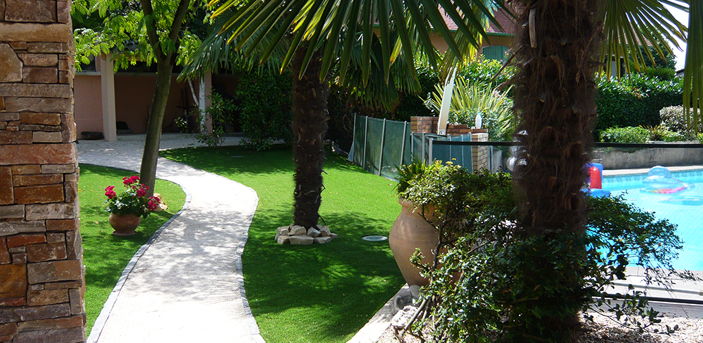 Artificial grass in a small garden around a swimming pool